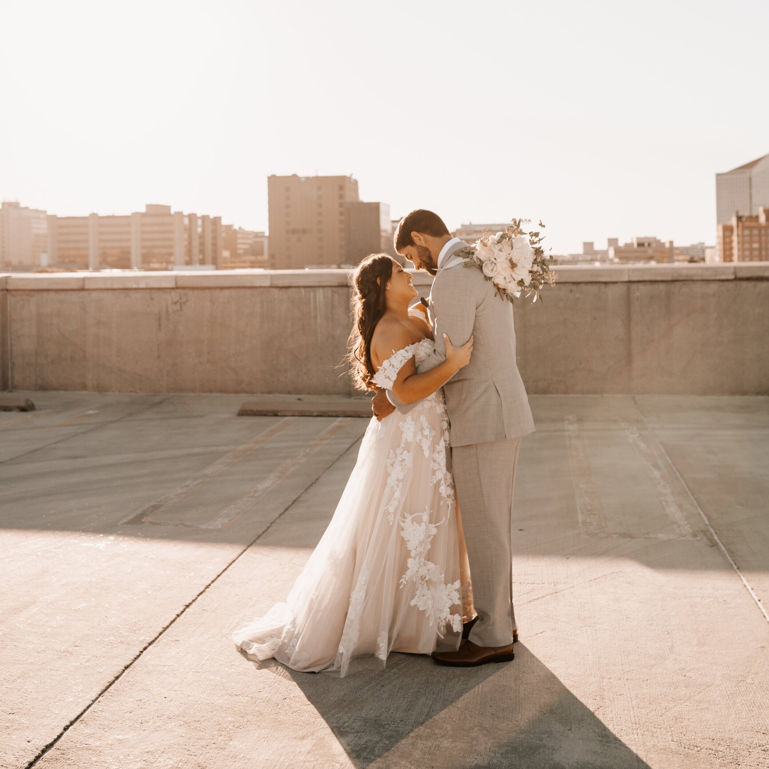 bride-groom-embracing-on-rooftop-against-wichita-skyline.jpg